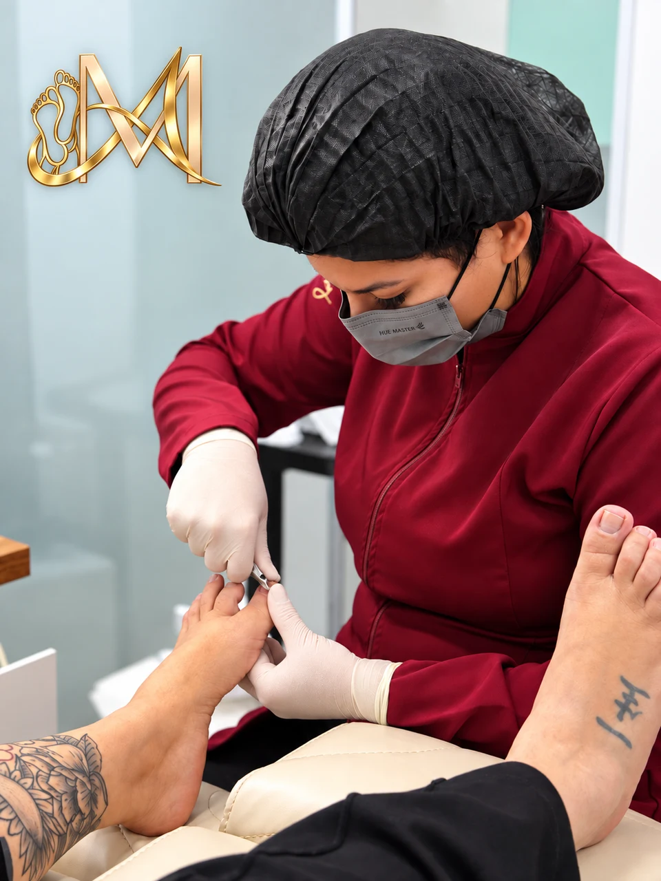 Profissional com máscara e luvas realizando cuidado nas unhas dos pés.